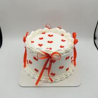 کیک ارتفاع دار سفید با قلب و روبان قرمز
